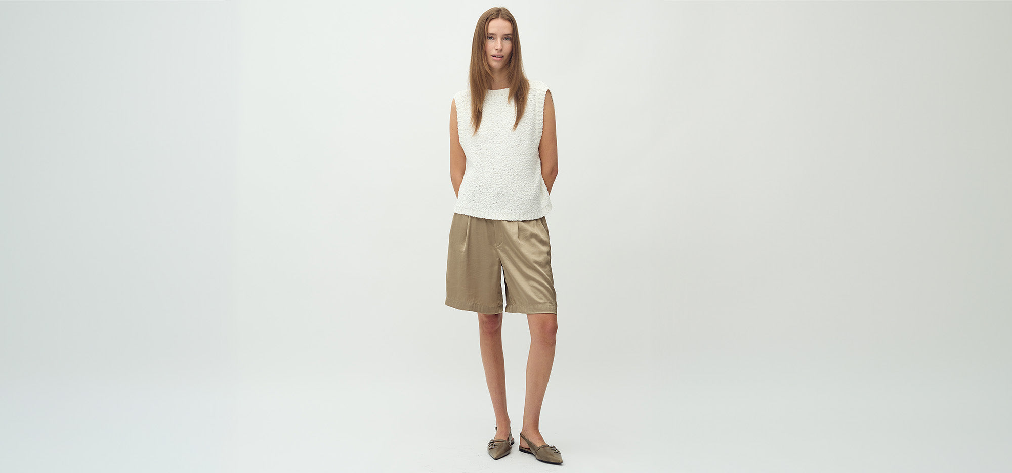 Vrouw draagt stijlvolle bermuda shorts – de perfecte mix van comfort en mode voor zomer 2025.