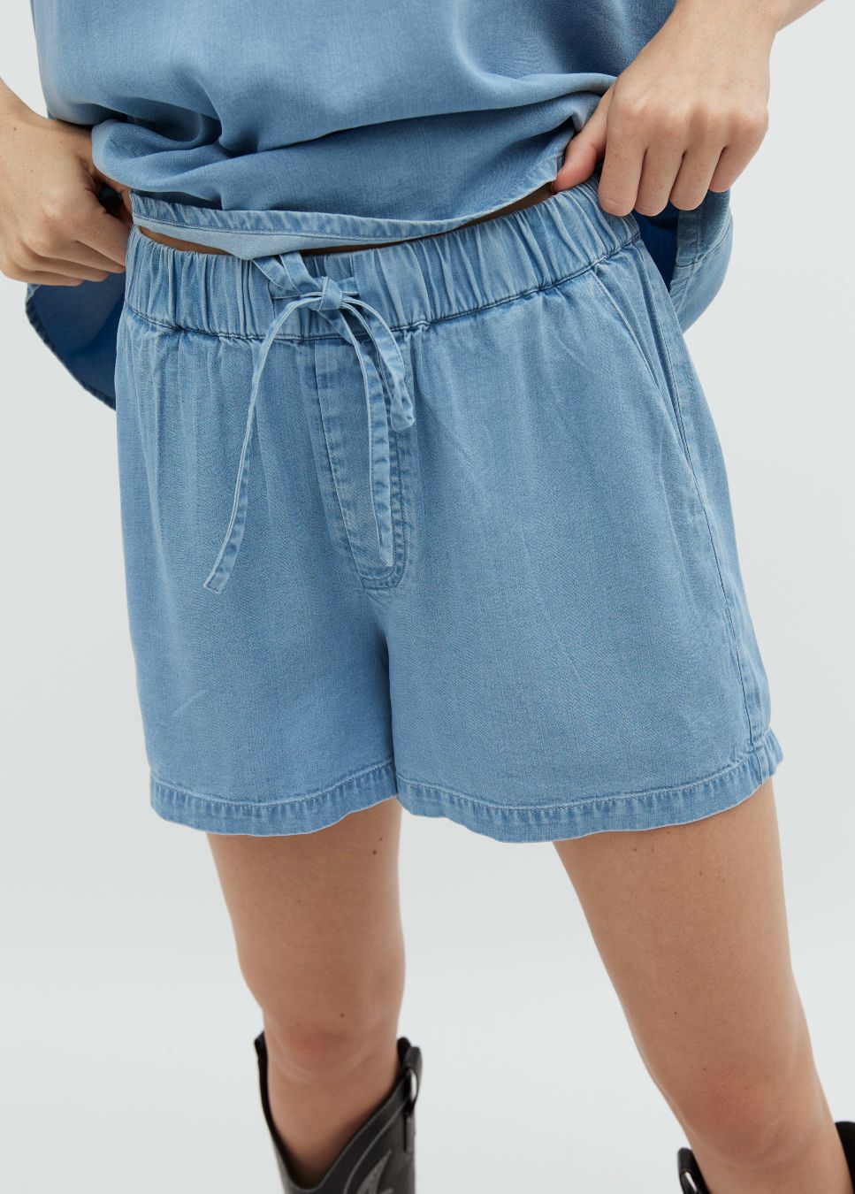 Blauwe korte short Juanis mbyM I Super leuk denim look shortje van het merk mbyM. De blauwe light vintage wash short heeft een elastische taille met strikceintuur, steekzakken en fake achterzakken. Shop de nieuwe collectie dames shorts, denim shorts, short van het merk mbyM bij dameskleding webshop Boetiek Aniek.