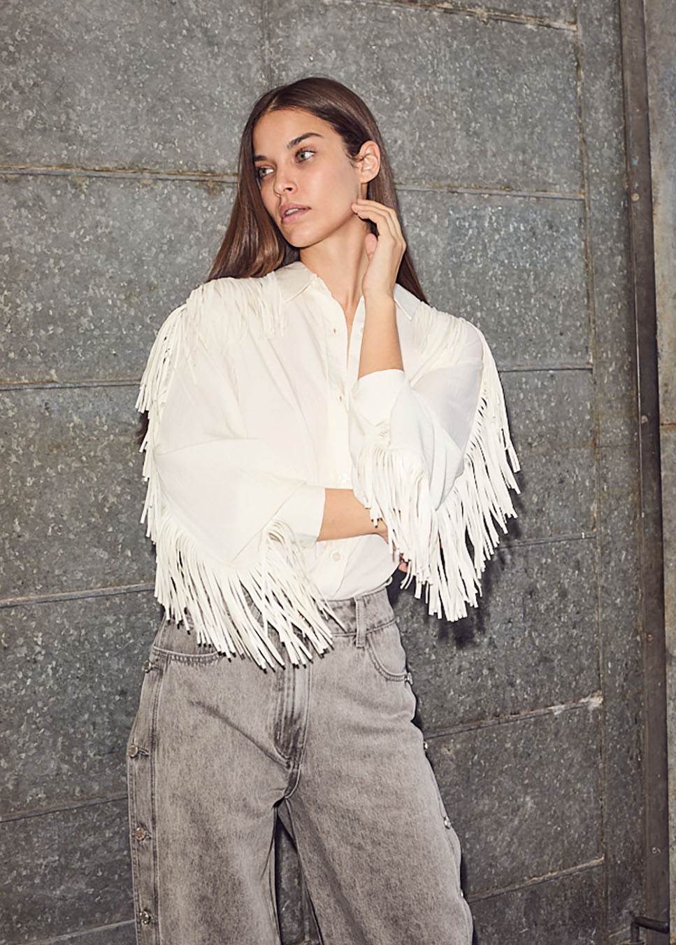 Haute L’Amitié Fringe blouse wit voorkant model met franjes op de mouwen en grijze jeans