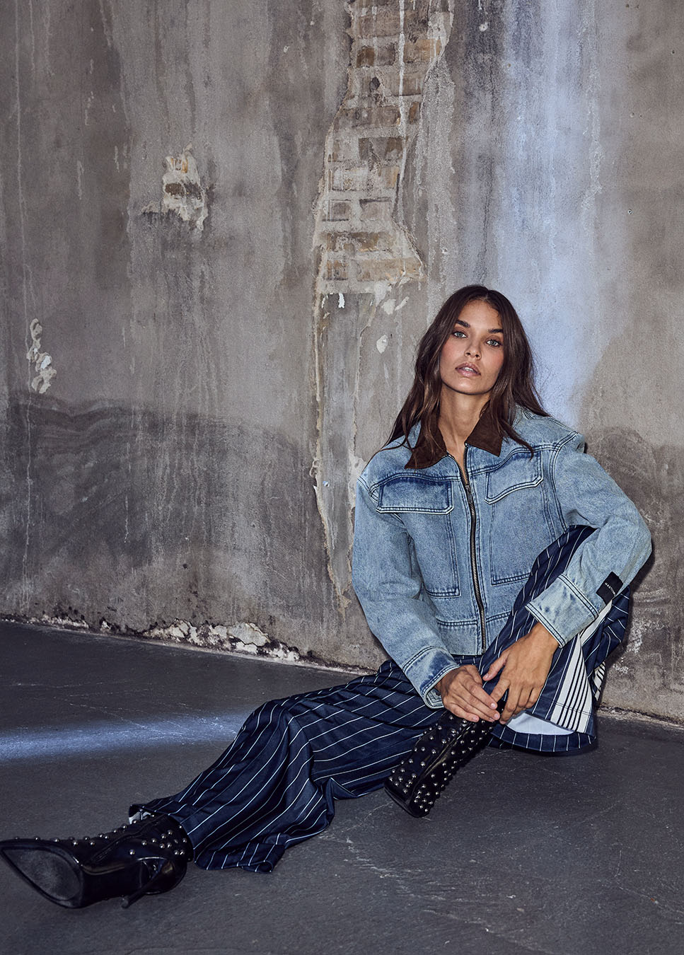 Haute L’Amitié Meliza Crop Denim Jacket blauw HL10492 voorkant model zittend met blauwe gestreepte track pants