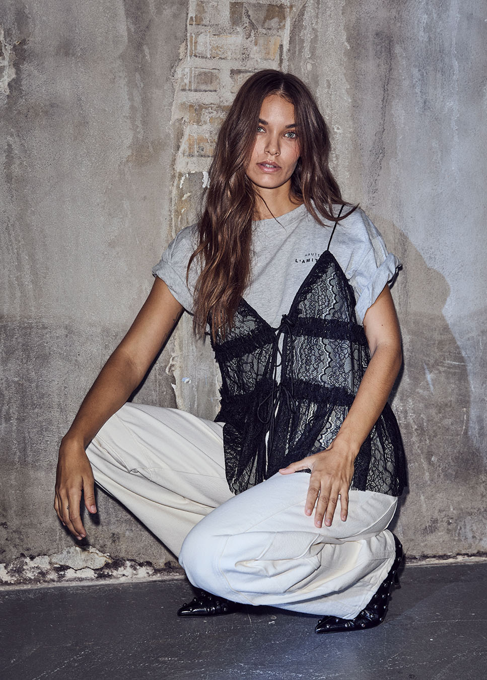 Haute L’Amitié New Lace Tie Top zwart voorkant model met grijs t-shirt en witte jeans