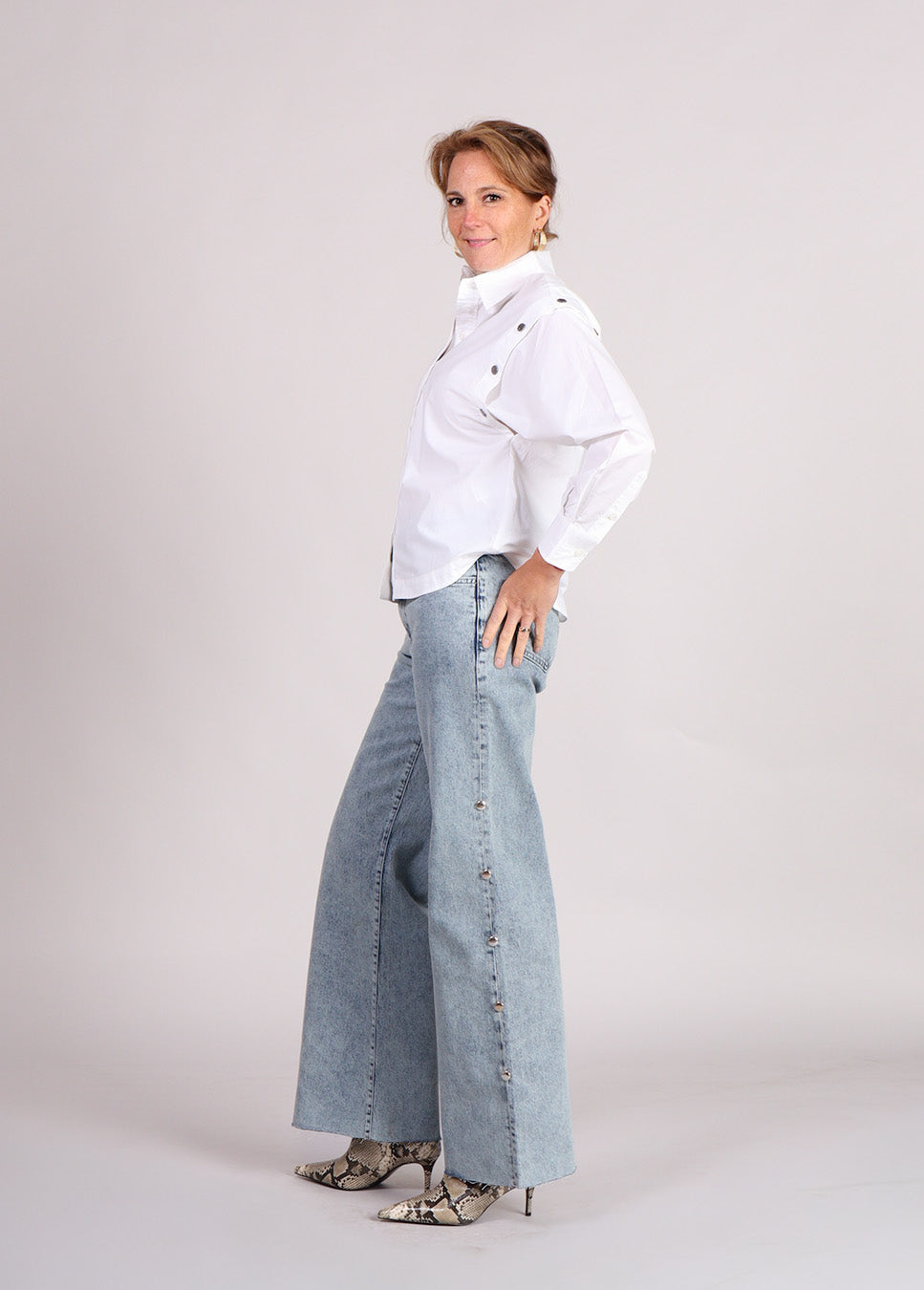 Homage mid waist wide leg jeans with big studs zijkant model met witte blouse