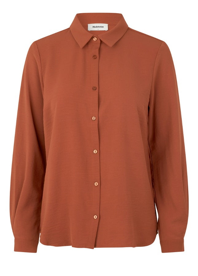 Roestbruine blouse Ossa van het merk Modstrom. De klassieke maple blouse heeft een loose fit. Het Ossa overhemd heeft een kleine kraag, smalle manchet en knopen in een bijpassende kleur voor een strak design.   Materiaal: 100% polyester.