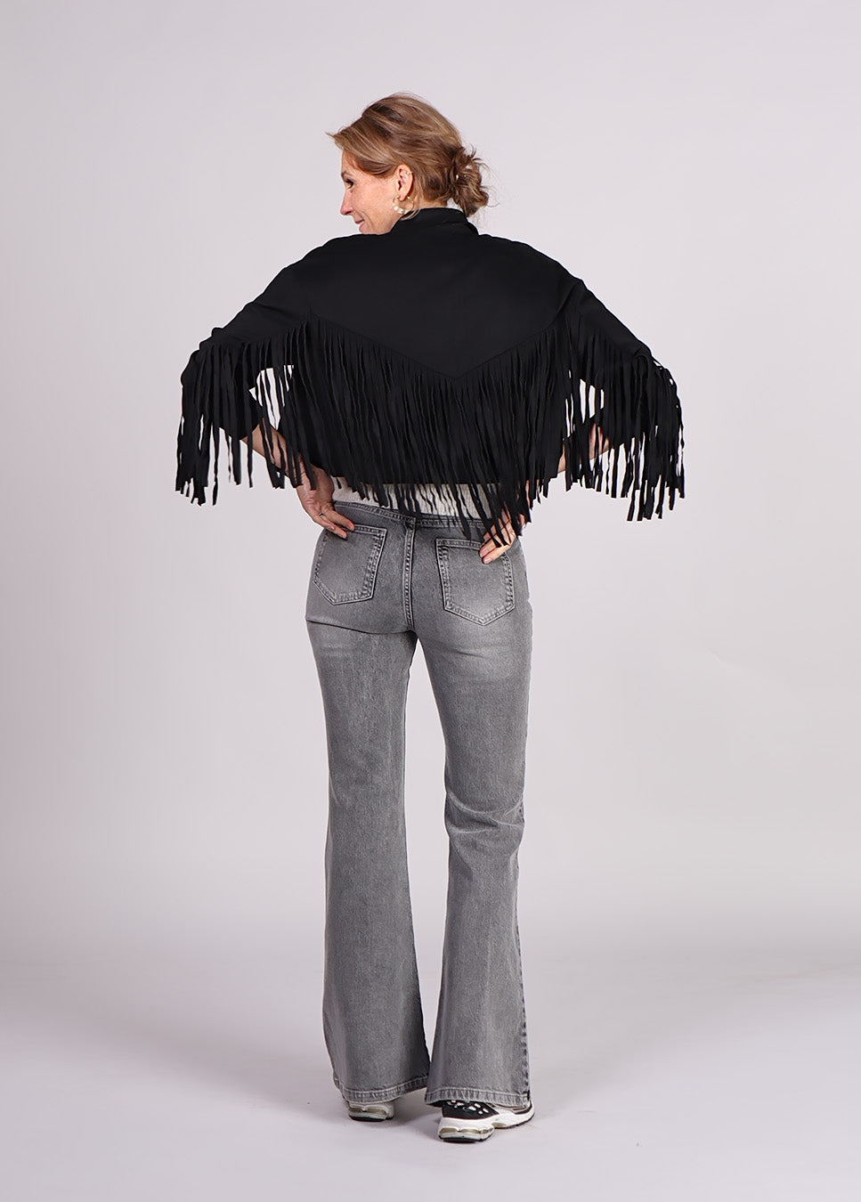 Studio Amaya Ilva jasje met franjes suede zwart achterkant model met grijze jeans