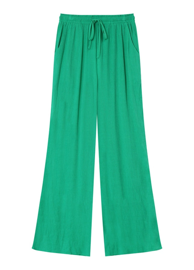 Groene pantalon Matisse van het merk Grace & Mila. De Matisse is een lange, wijde broek met een elastische taille met strikband en steekzakken aan de zijkant. De perfecte broek voor de warme zomerdagen. Combineer de groene pantalon met de bijpassende groene oversized blouse voor een comfortabele en elegante look. 
