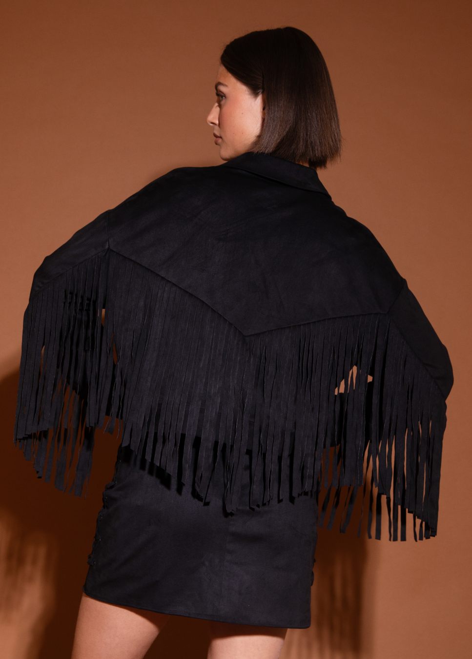Achterkant van het studio amaya ilva jasje suede met franjes zwart van kleur op model