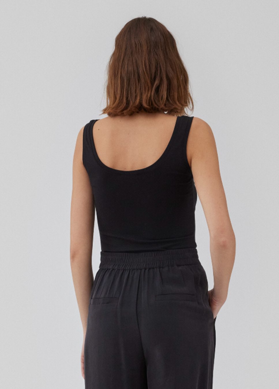 Zwarte top Hima I Zwarte aansluitende basic top Hima van het merk Modstrom. De top met stretch heeft brede bandjes en een diepe ronde hals gemaakt in gerecyclede kwaliteit. De zwarte top heeft een strak silhouet. Shop de nieuwe collectie dames tops, basic dames tops, Modstrom tops, zwarte basic hemdjes bij Boetiek Aniek.