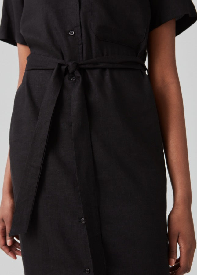 Zwarte linnenmix blousejurk van het merk Modstrom. De zwarte midi-jurk Darrel heeft een resortkraag, korte mouwen, een borstzakje, knopen aan de voorkant. De zwarte jurk heeft een brede strikceintuur in de taille, waardoor je de jurk mooi kunt tailleren. De perfecte zomerjurk. Shop de nieuwe collectie jurken online.